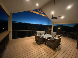 Covered deck dining area with evening lighting