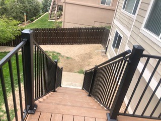 Finished deck stairs with black metal railings